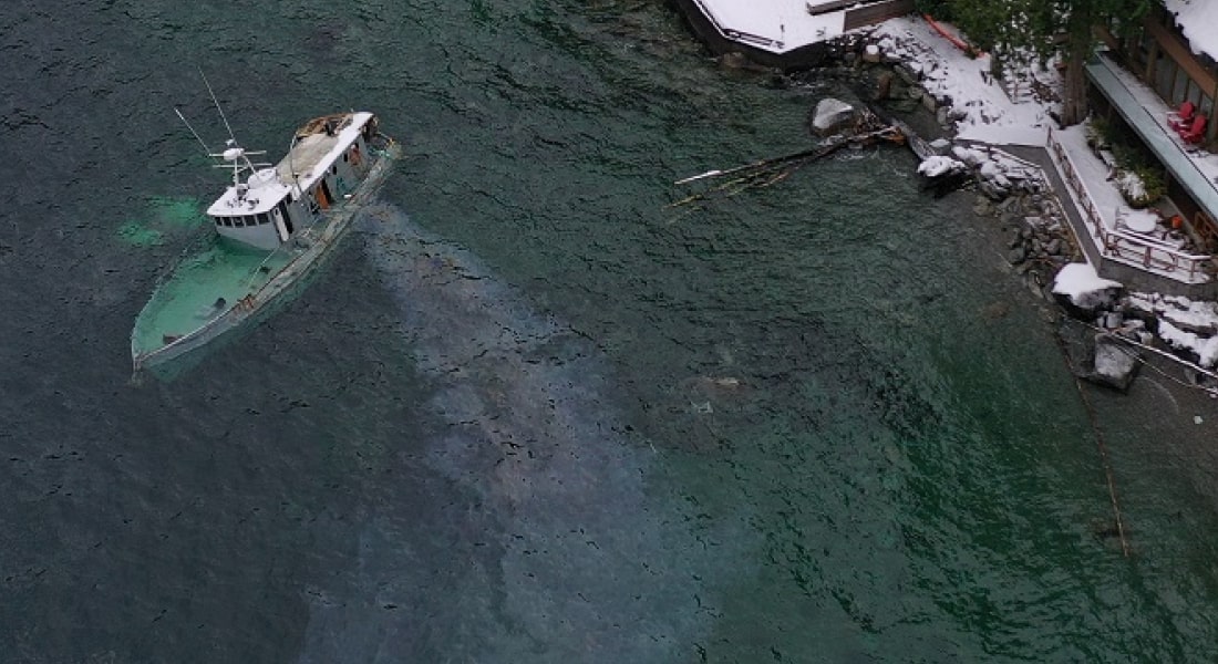 Overhead shot of sinking ship with oil spill.